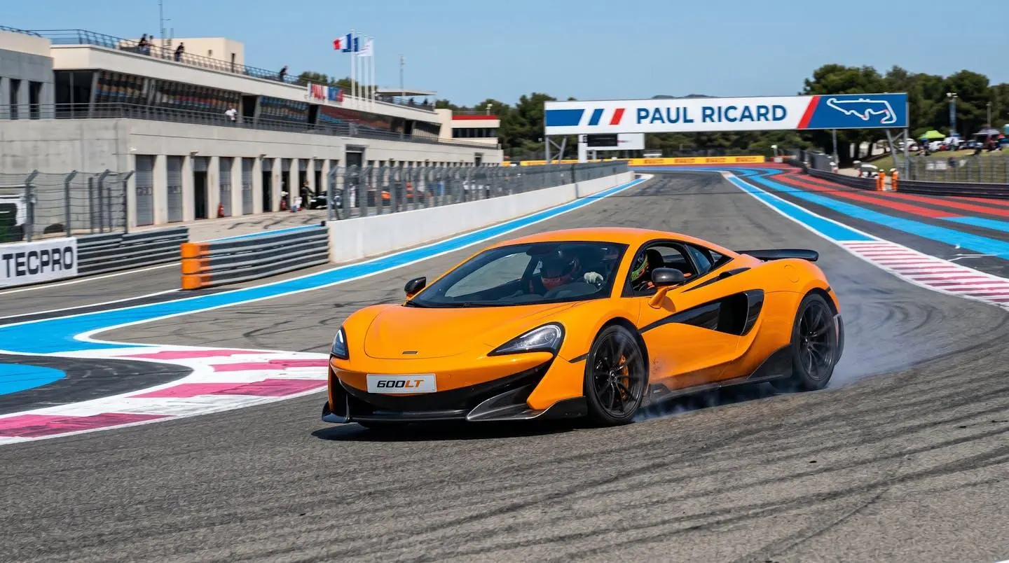 McLaren 720S en courbe dynamique sur circuit automobile français avec fumée de freinage visible illustrant sollicitation mécanique intense lors d'utilisation trackday